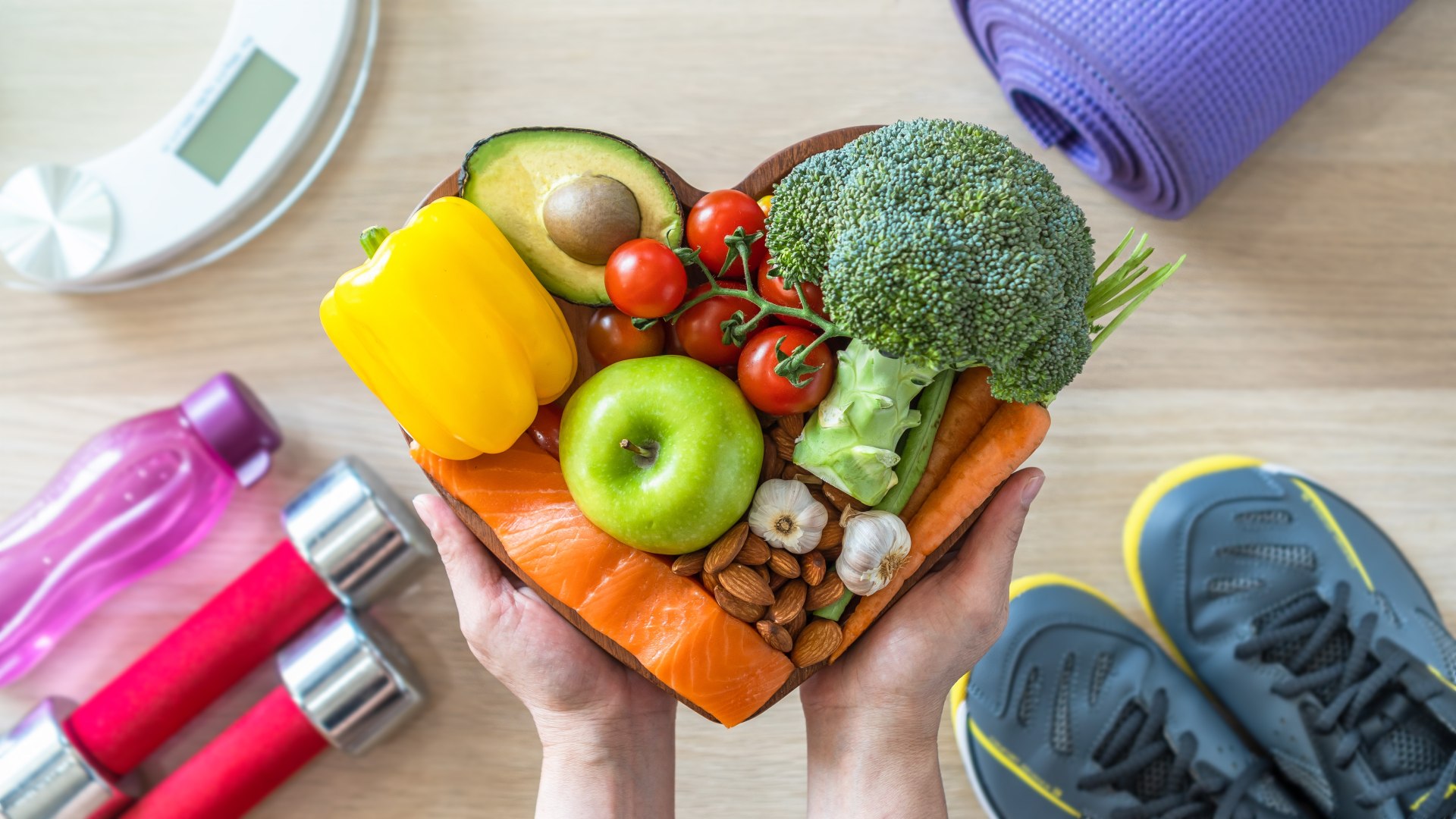 Alimentación sana: una persona sostiene un plato en forma de corazón con frutas y verduras